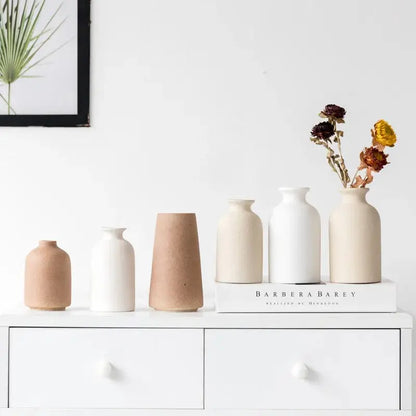 a group of vases sitting on top of a white dresser