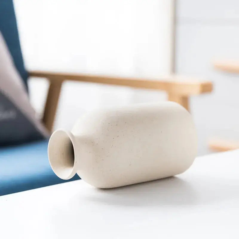 a white vase sitting on top of a white table