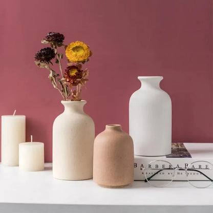 a table topped with vases filled with flowers and candles