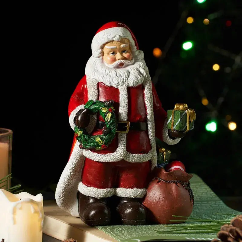 a santa clause figurine holding a christmas wreath
