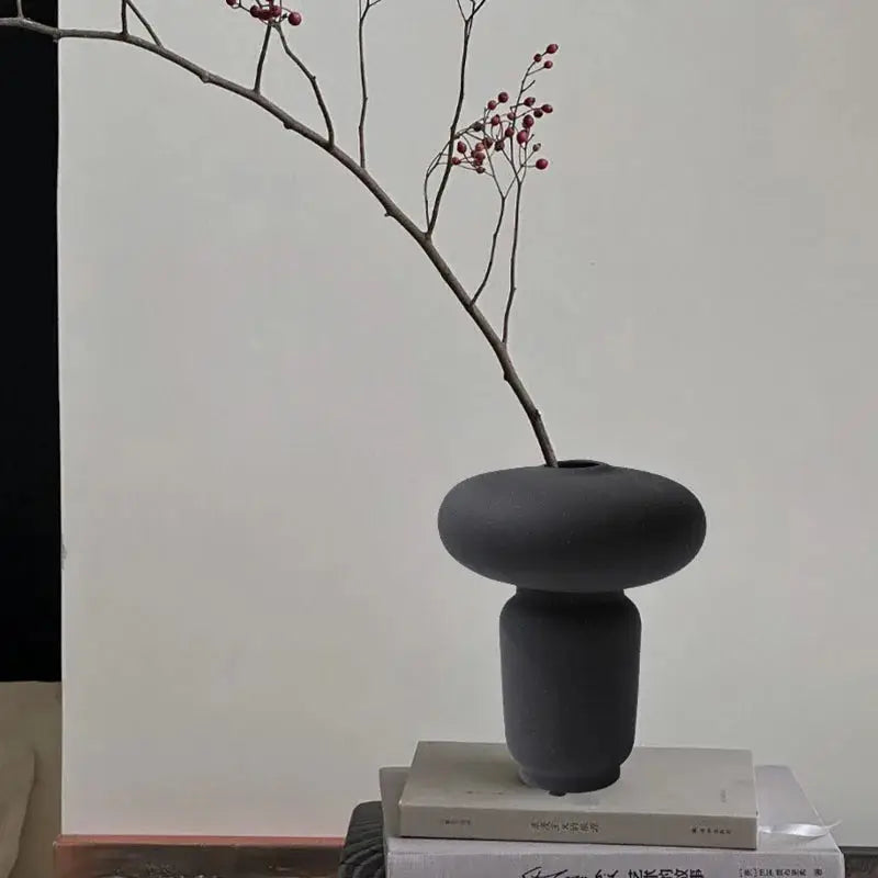 a vase sitting on top of a stack of books