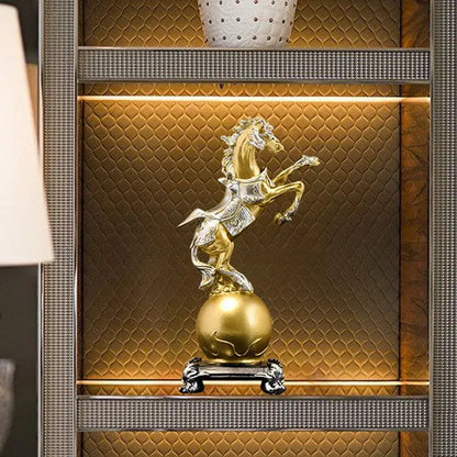 a gold horse statue sitting on top of a golden ball