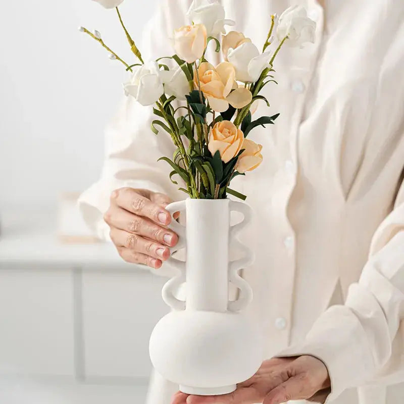 a woman holding a vase with flowers in it