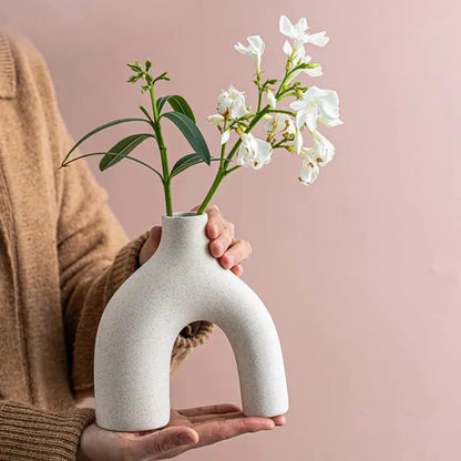 a person holding a vase with flowers in it