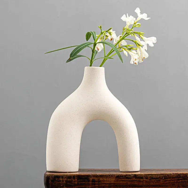 a white vase with some flowers in it