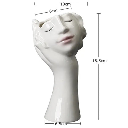 a white ceramic sculpture of a woman's head with her eyes closed