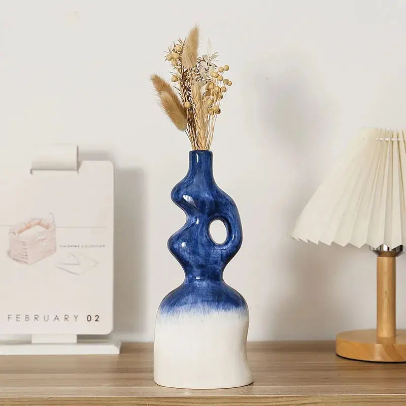 a blue and white vase sitting on top of a wooden table