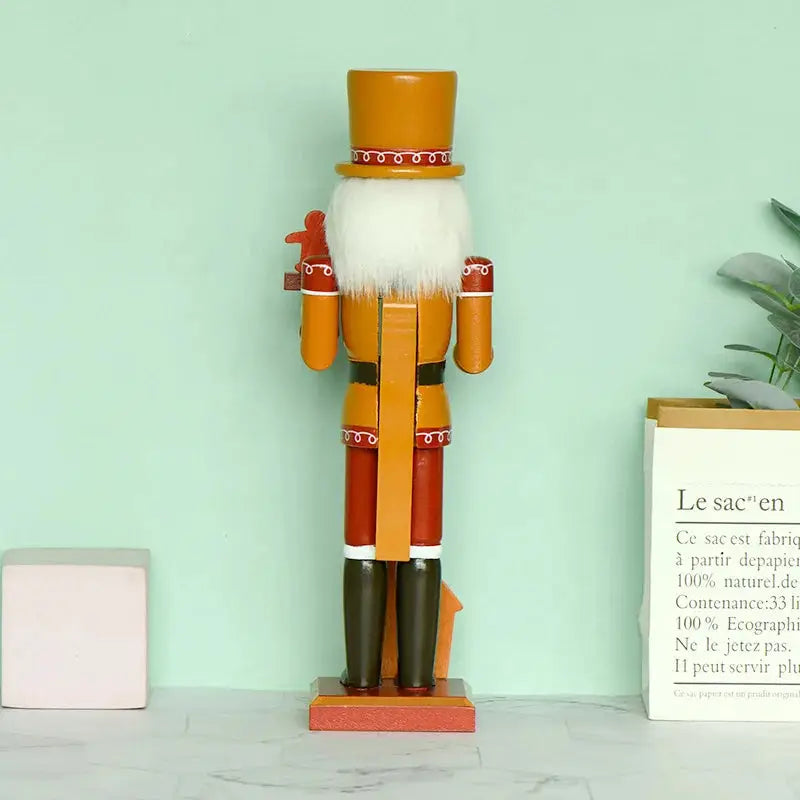 a wooden nutcracker standing on a table next to a plant