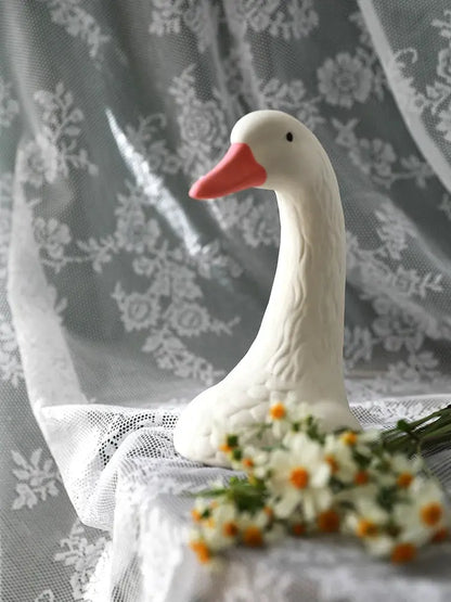 a white duck sitting on top of a table