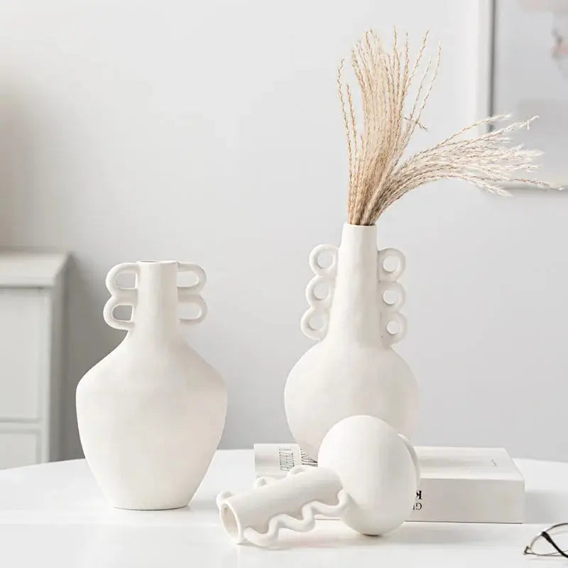 a couple of white vases sitting on top of a table