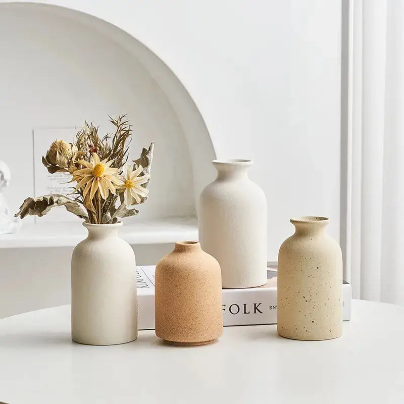 three vases sitting on a table with flowers in them