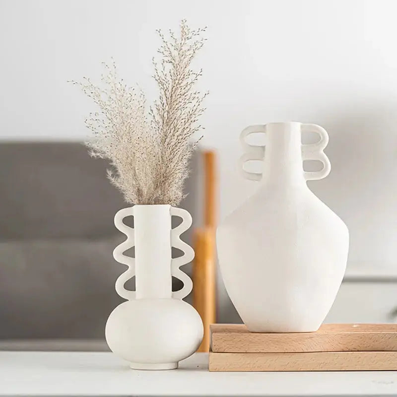 two white vases sitting on a white table