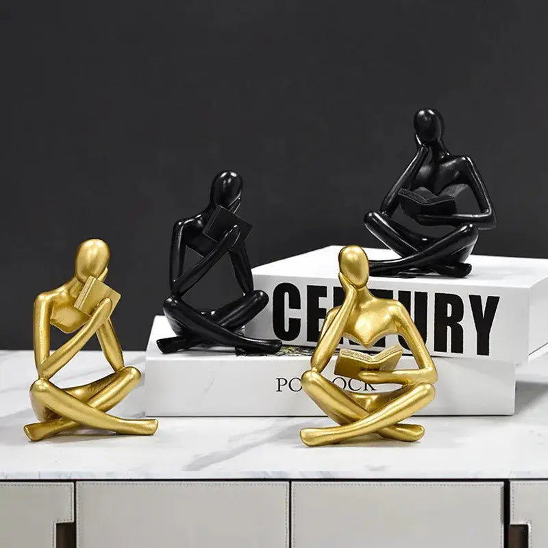 three gold and black figurines sitting on a table