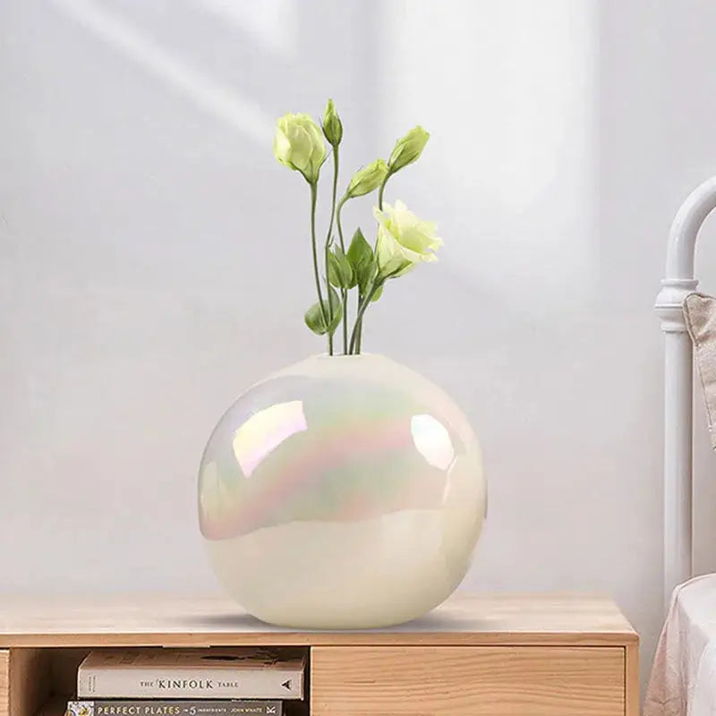 a white vase with some flowers in it