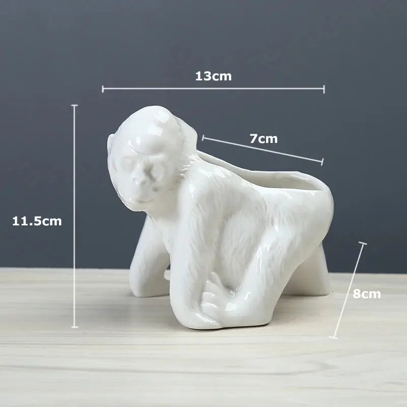 a white ceramic monkey figurine sitting on a table