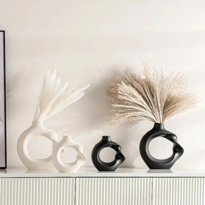 a white shelf with three black vases and a picture