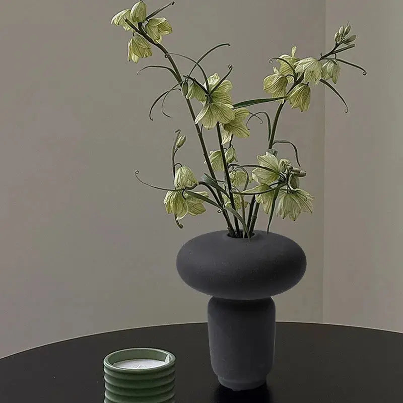a black table with a vase with flowers in it