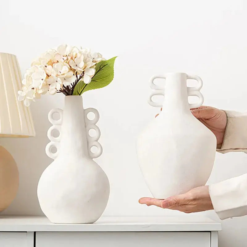 a person holding a vase with a flower in it