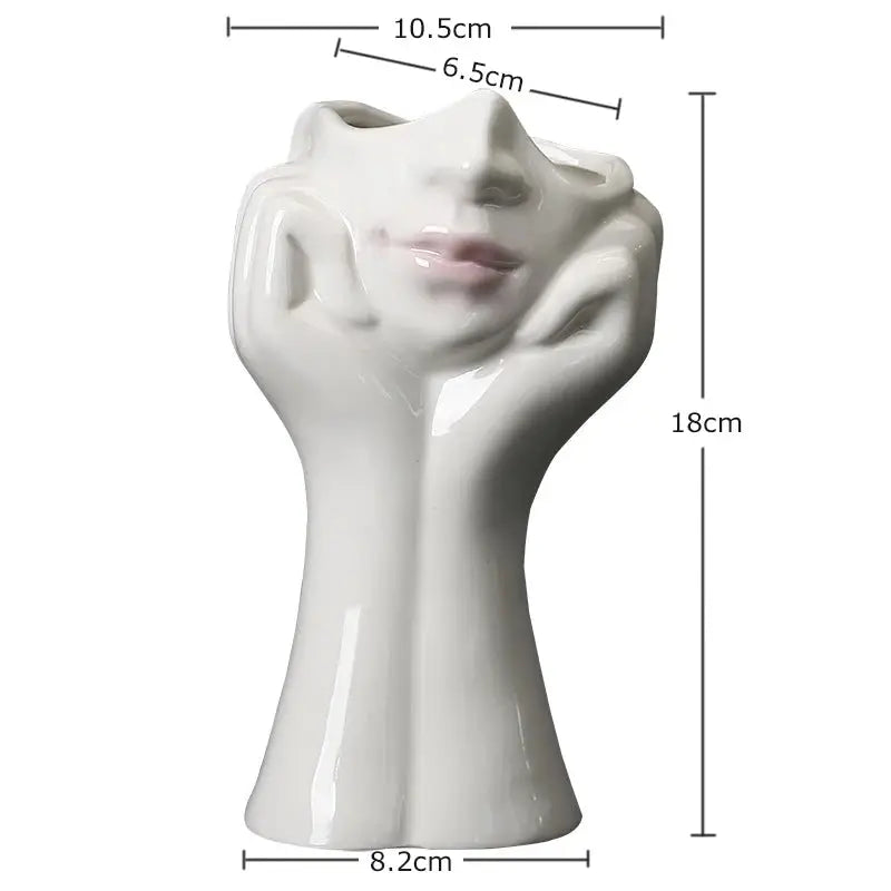 a white vase with a face and hands on it