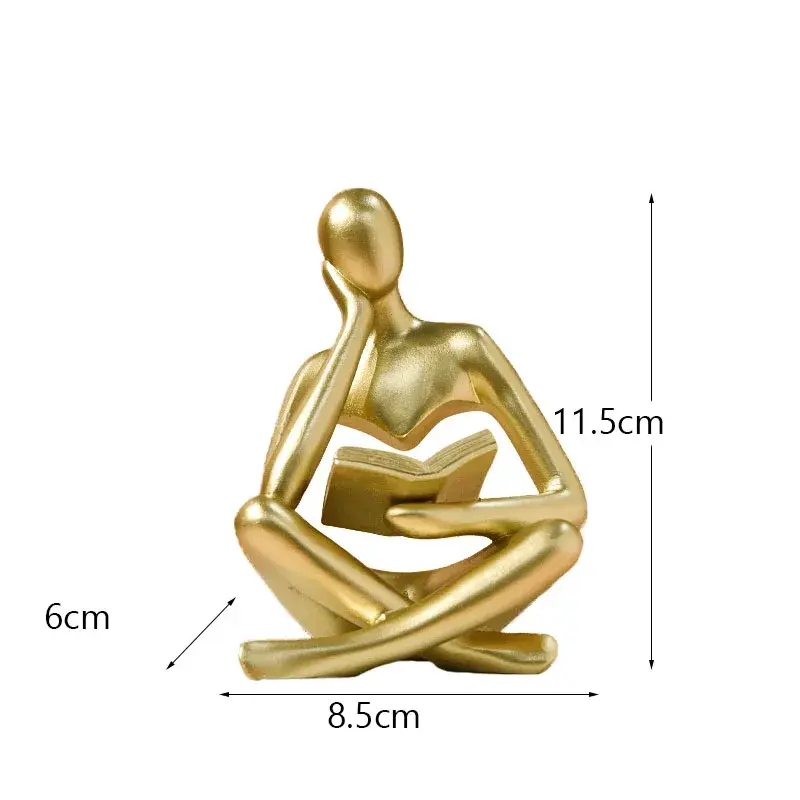 a gold statue of a person sitting in a yoga position