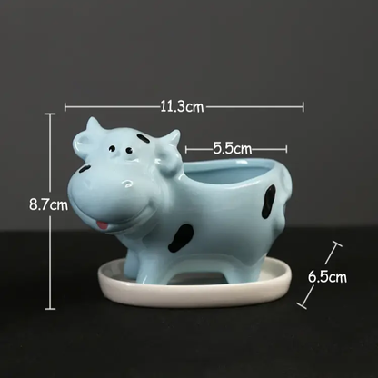 a ceramic cow planter is shown on a table