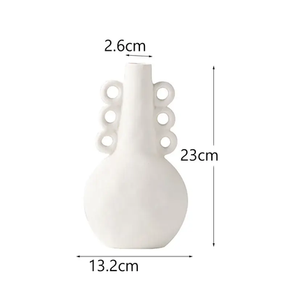 a white vase with holes in the middle of it